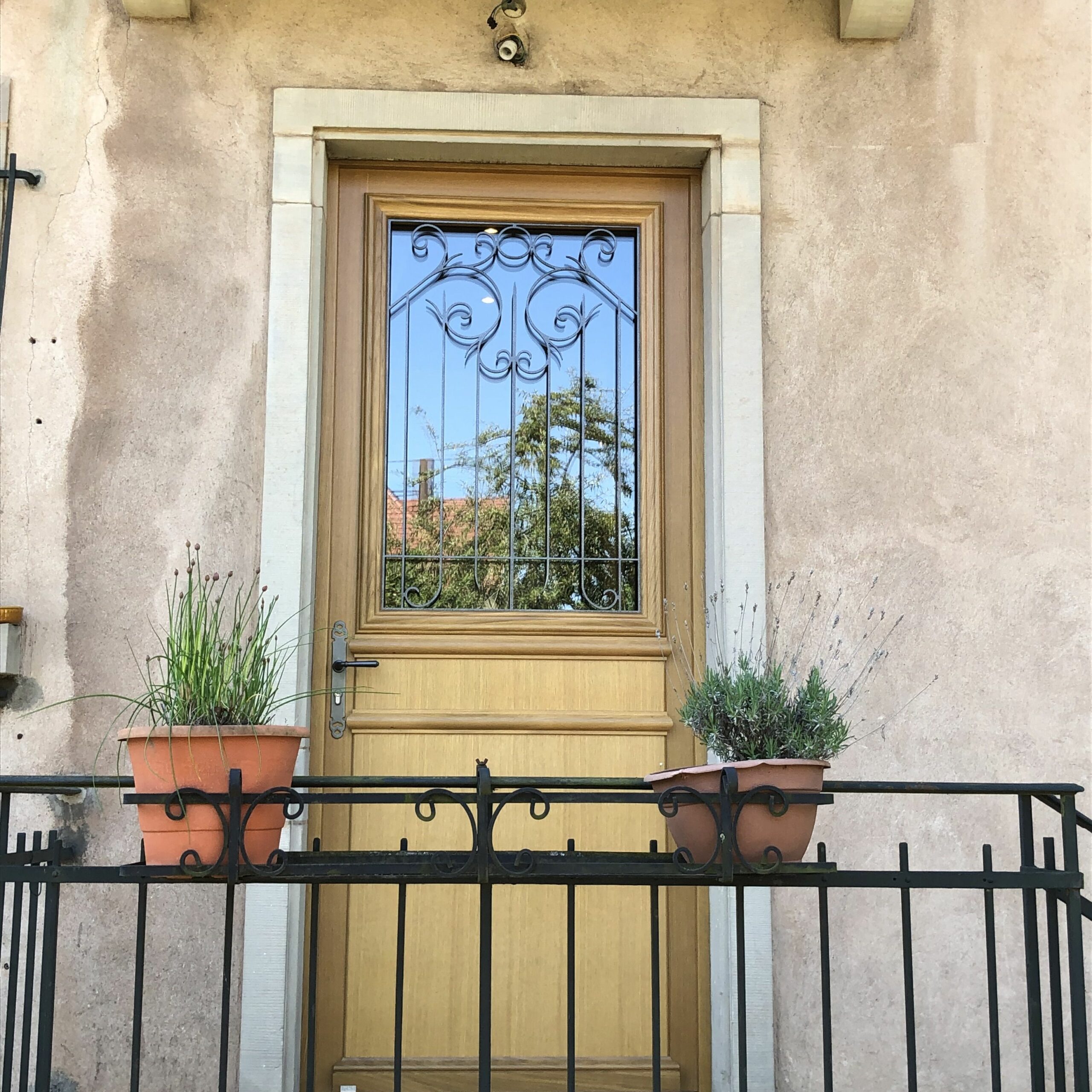 Une porte d'entrée sur mesure en bois avec un vitrail et une poignée en laiton.