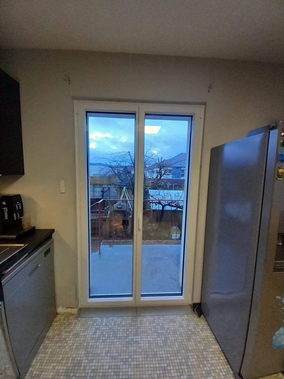 Baie vitrée Fullsun dans une cuisine donnant sur une terasse.

C'est le crépuscule mais la lumière extérieur entre tout de même dans la pièce.