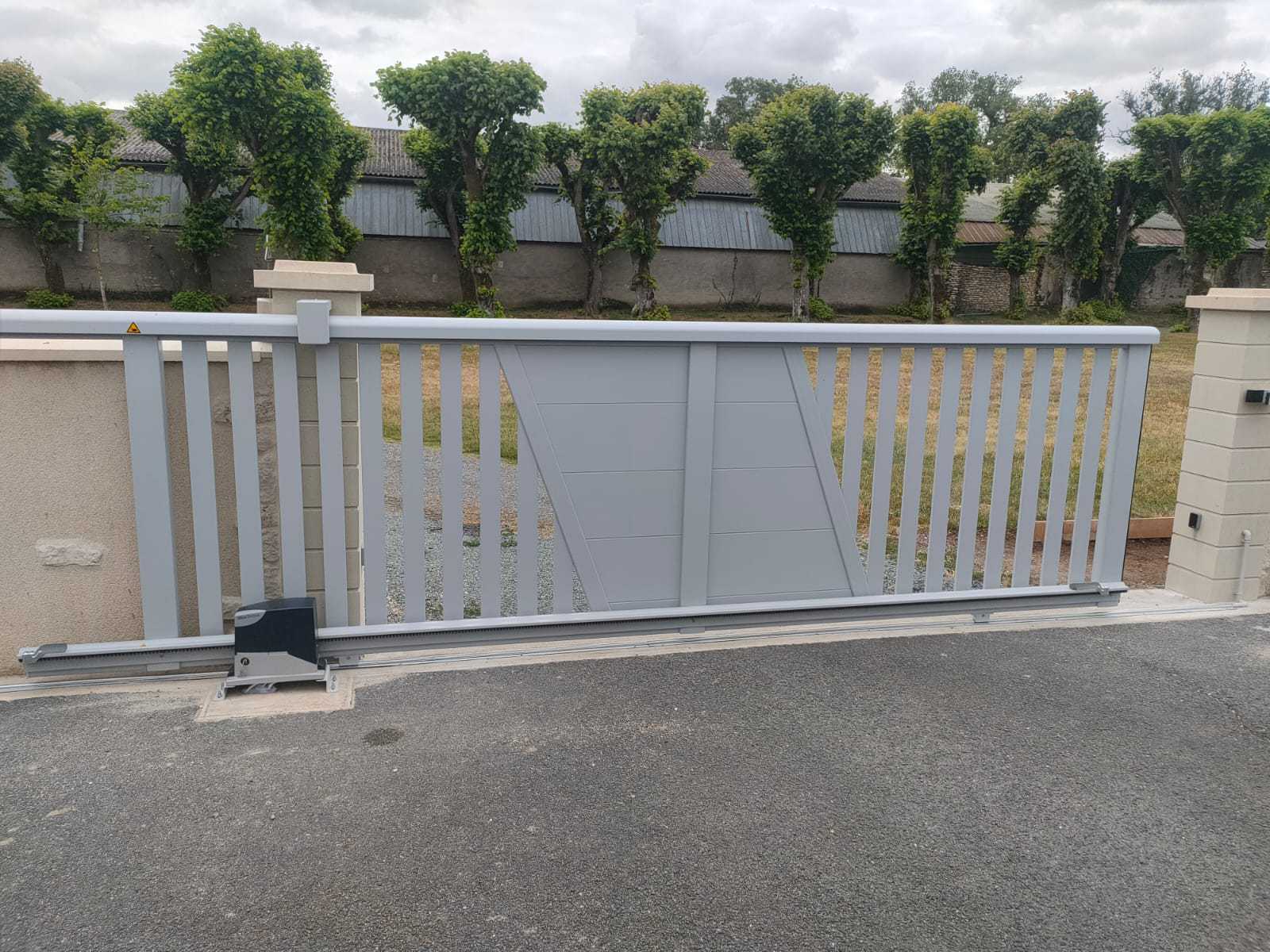 Image d'un portail coulissant 3m gris anthracite en aluminium, installé devant une maison moderne avec des arbres en arrière-plan.